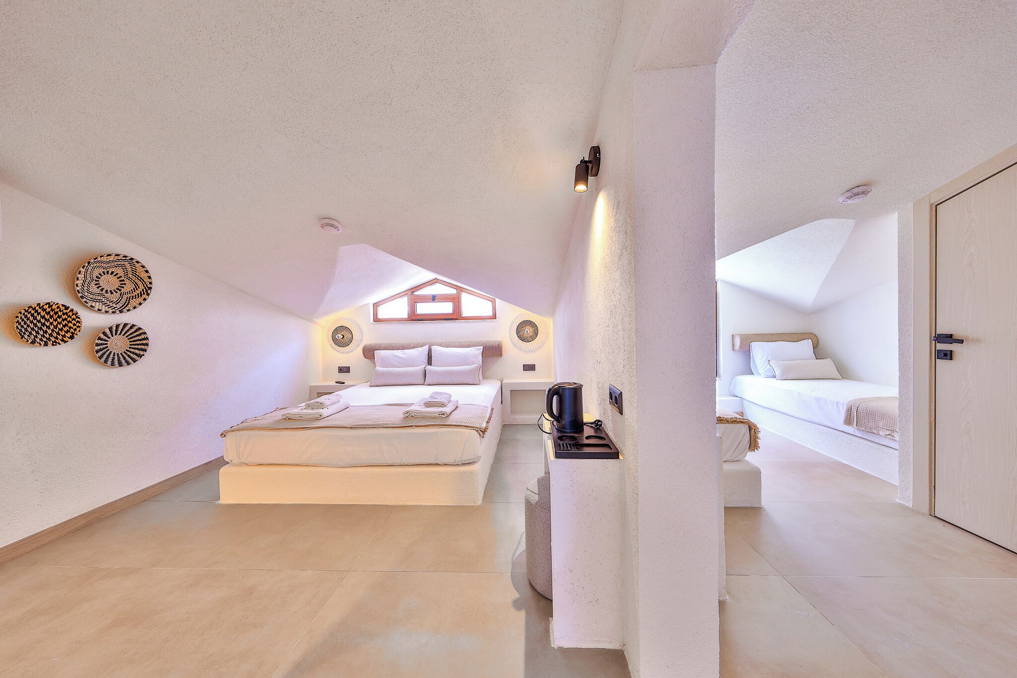 Een slaapkamer met een bed, nachtkastje en een lampje aan de muur.