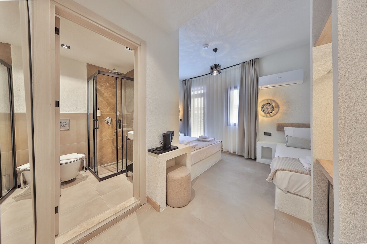 A modern bathroom with a glass shower enclosure, a toilet, and a sink.