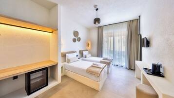 Ein Hotelzimmer mit Bett, Nachttisch, Fernseher und einer kleinen Sitzecke.