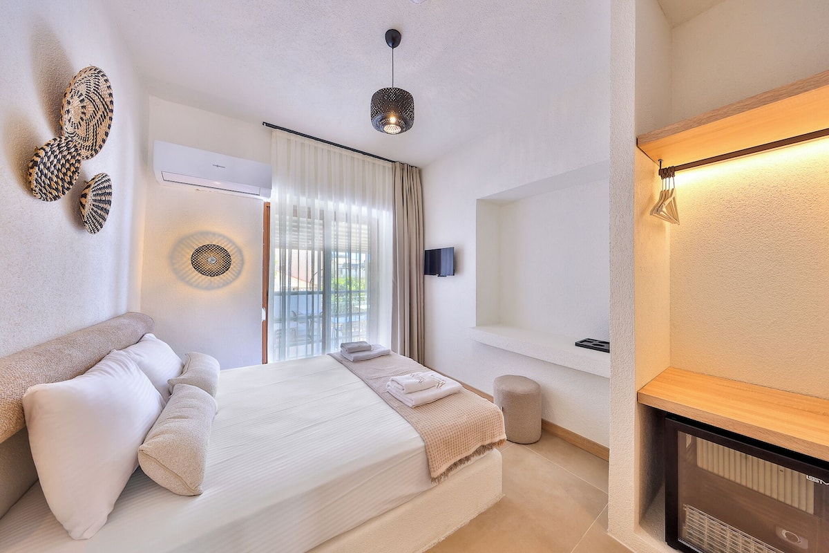 A modern bedroom with a bed, a bedside table, a wall-mounted TV, and a window with curtains.