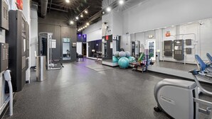 Ein Fitnessraum mit Trainingsgeräten, einem großen Spiegel und einer Tür mit der Aufschrift 'Final Room'.