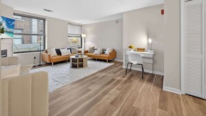 Ein modernes Wohnzimmer mit einer Couch, einem Couchtisch und einem Schreibtisch mit Stuhl.