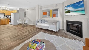 Ein modernes Wohnzimmer mit einer Couch, einem Kamin und einem an der Wand befestigten Fernseher.