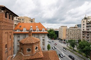 Eine Stadtansicht mit einem markanten Gebäude, das ein rotes Ziegeldach und einen mit einer Uhr versehenen Turm hat.