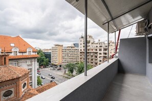 Ein Balkon mit Blick auf eine Stadtlandschaft, einschließlich Gebäude und einer Straße.