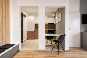 Eine moderne Küche mit Essbereich, Holzboden und einem an der Wand befestigten Fernseher.