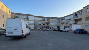 Ein mehrstöckiges Wohngebäude mit Parkplatz.