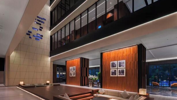 A modern hotel lobby with a spacious seating area, wooden accents, and large windows. - Songshan Lake Intercity Hotel (Dongguan)