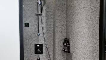 A modern shower with a handheld showerhead and a wall-mounted faucet.