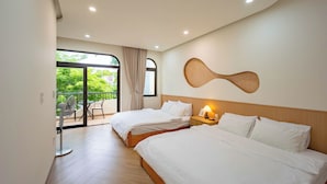A hotel room with two beds, a ceiling fan, a wall-mounted light, and a view of greenery outside. - Hometown Nimi 3 BRS Pool Villa Da Nang (Da Nang)