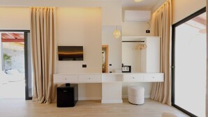 A modern bedroom with a large mirror, a flat-screen TV, a wardrobe, and a desk. - Luxury Villa Oasis (Ksamil)