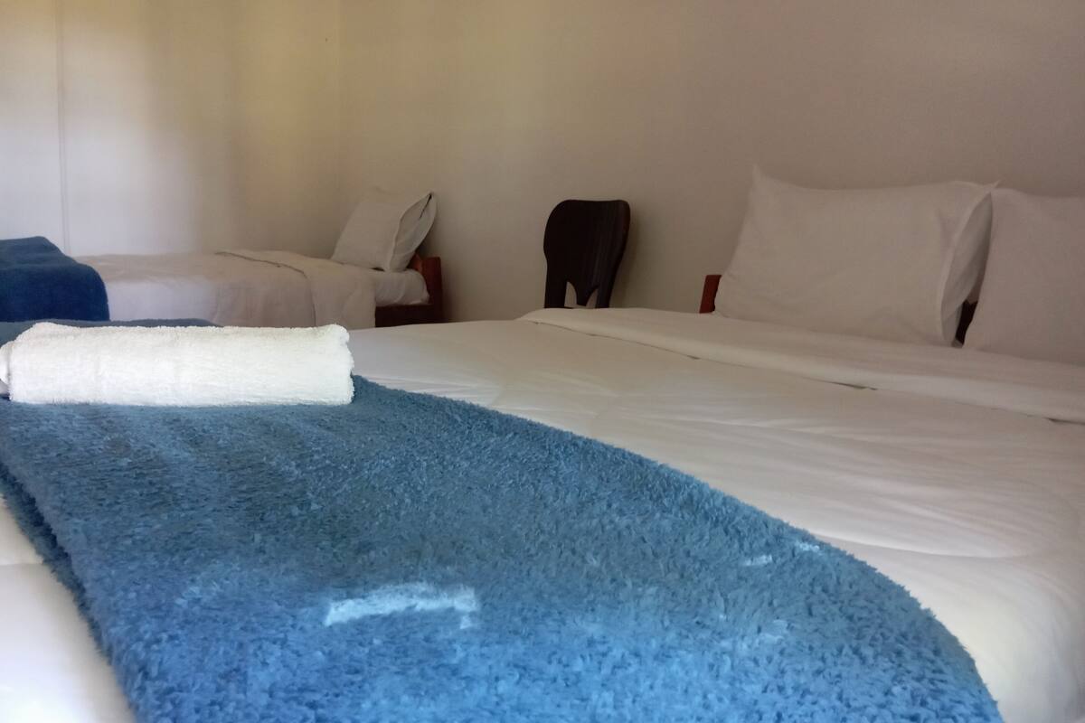 Ein Hotelzimmer mit einem Bett, einer blauen Decke und einem weißen Kissen.