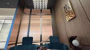 A modern interior with a round table, blue chairs, a chandelier, and a large window. - Crystal Orange Shenzhen Luohu Port (Shenzhen)
