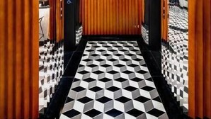 Un pasillo con suelo de estampado geométrico, paneles de madera verticales y un estilo moderno.