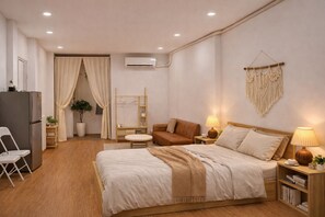 Quarto de hotel moderno com cama, mesas de cabeceira, escrivaninha, cadeira, guarda-roupa e ar condicionado.