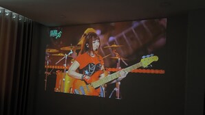 A television screen displaying a person playing a guitar. - Peanuts Home Le Lai - Chic Local Stay, Steps to Ben Thanh & Bui Vien (Ho Chi Minh city)