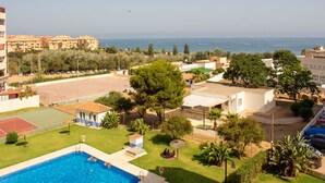Zona residencial con piscina, cancha de tenis y vista al mar.