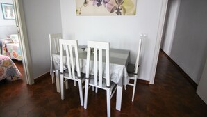 A dining area with a table and chairs, a painting on the wall, and a patterned rug. - P Andaluz 670 by At Home Costa del Sol (Torrox)