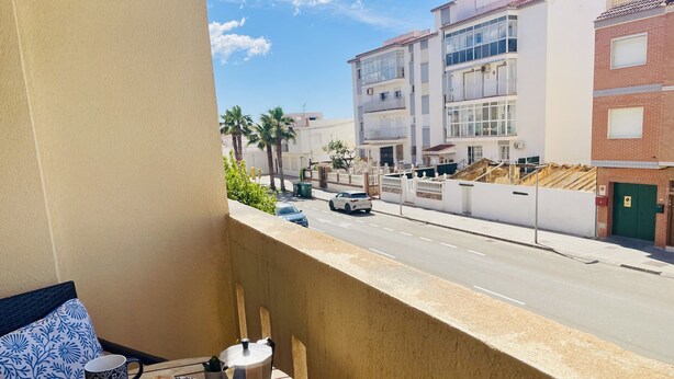 A balcony with a table set for two, a coffee pot, and a book. - Albatros 1 by At Home Costa del Sol (Algarrobo)