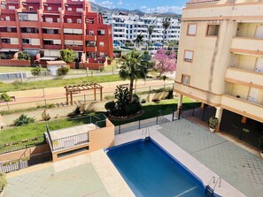 Ein Wohngebäude mit Schwimmbad, einer Pergola und einem gepflegten Garten.