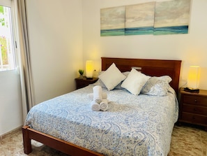 A neatly made bed with a patterned bedspread, two bedside lamps, and a wall art piece above the bed. - P Andaluz 921 by At Home Costa del Sol (Torrox)