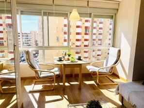 Een modern appartement met een groot raam, houten vloeren en twee stoelen.
