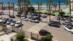 A parking lot with cars, palm trees, and a view of the beach. - Ruselo 308 by At Home Costa del Sol (Torrox)