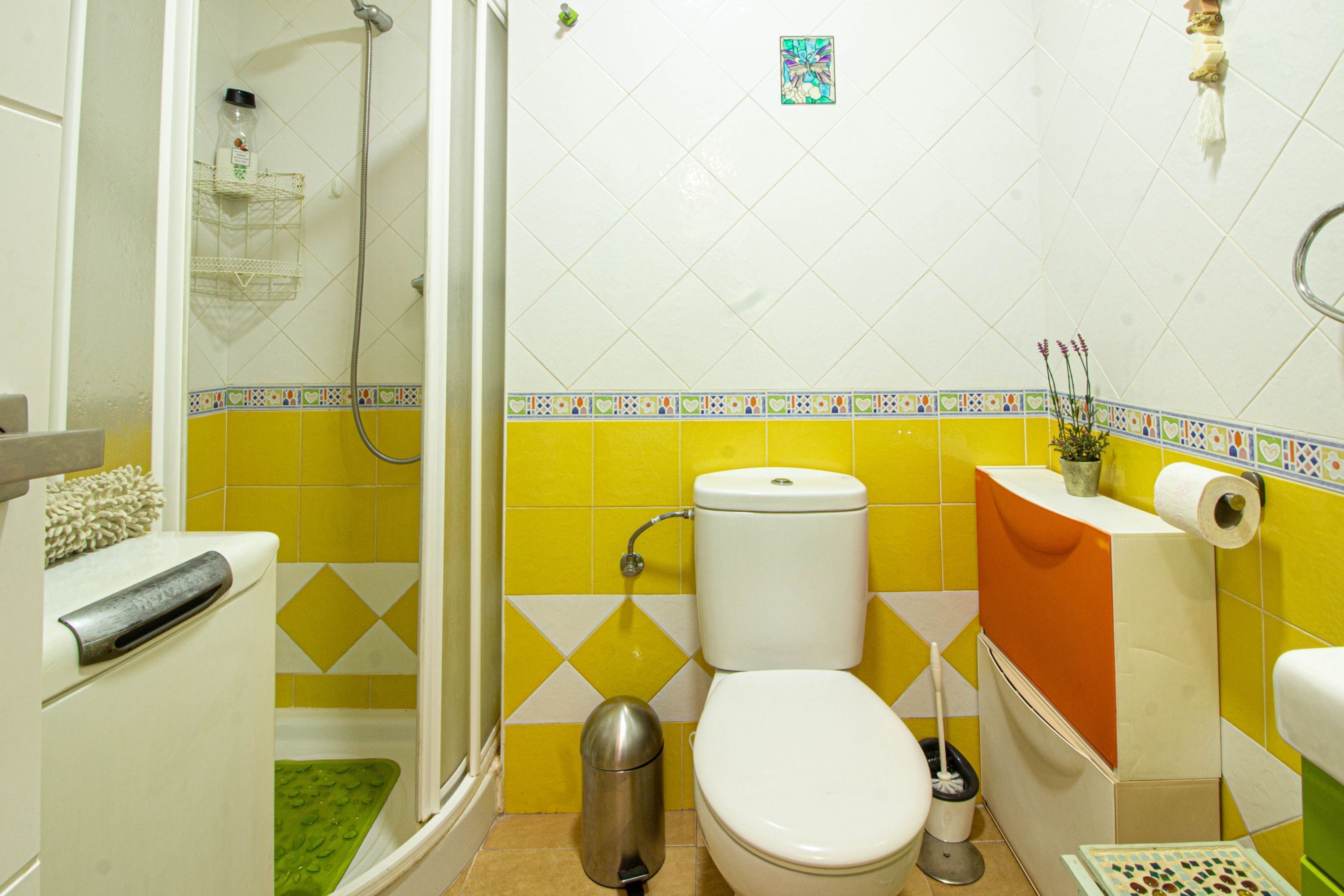 A bathroom with a shower, toilet, and sink.