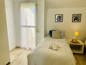 A hotel room with a bed, a nightstand with a lamp, and two framed pictures on the wall. - Albatros 3 by At Home Costa del Sol (Algarrobo)