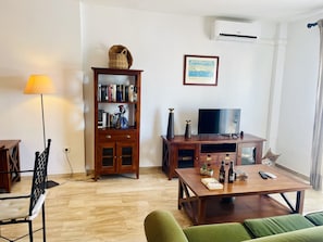 A living room with a wooden cabinet, a television, a lamp, and a sofa. - Albatros 3 by At Home Costa del Sol (Algarrobo)