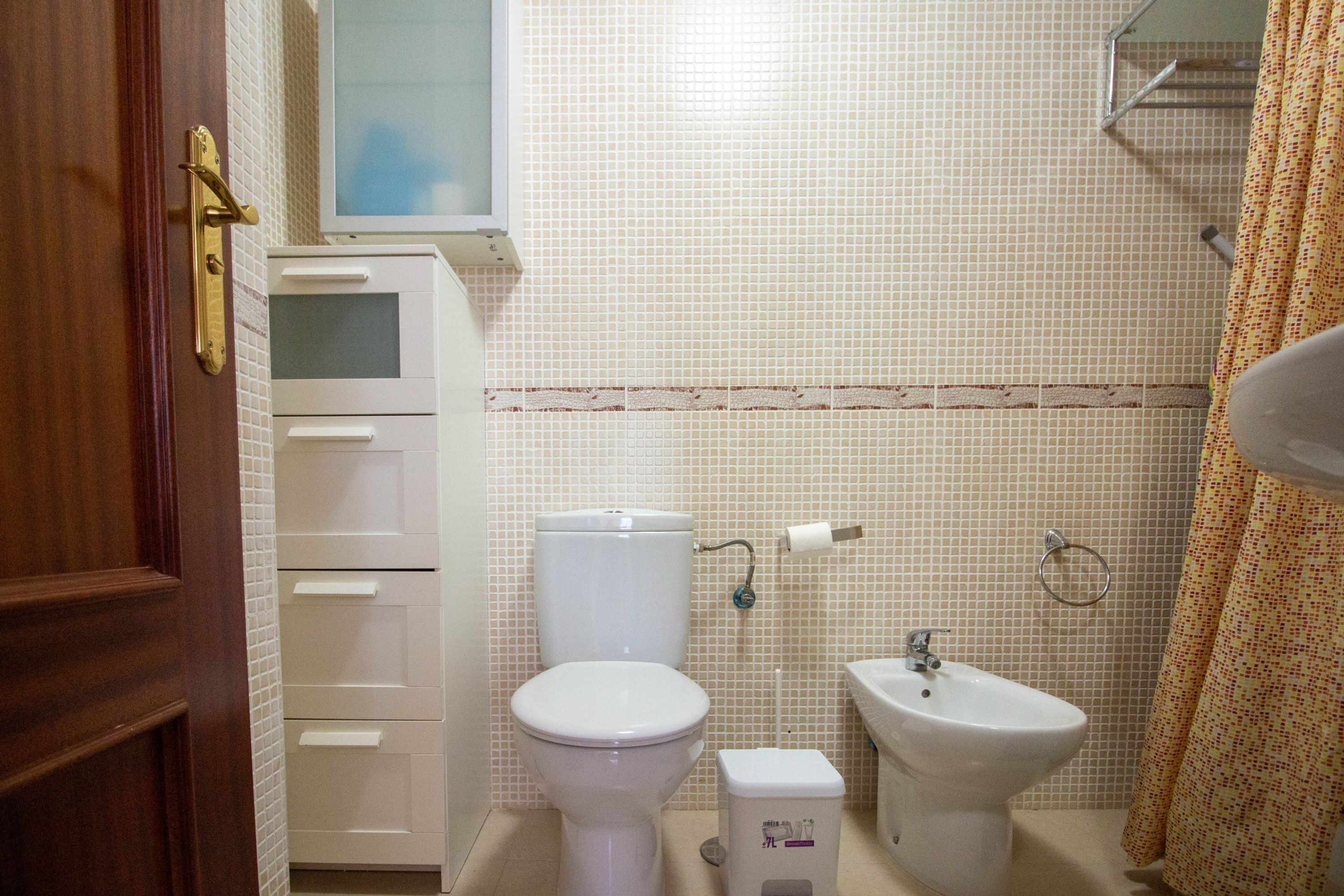 Un baño con inodoro, bidé y lavabo.