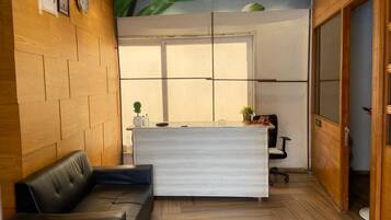 Una recepción con pared de madera, un sofá de cuero negro y una puerta con la etiqueta 'SPA'.