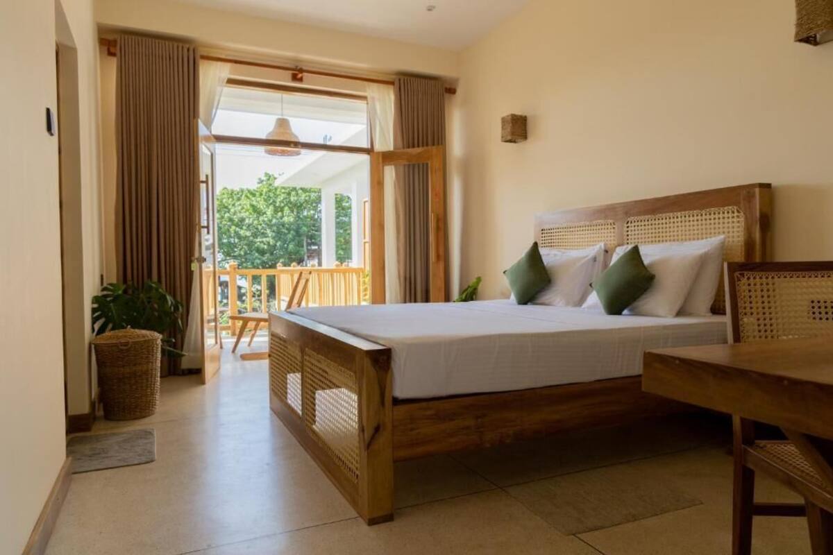 Una camera da letto con un letto di legno, un balcone e vista sul verde.