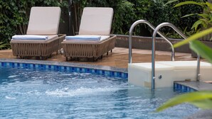 A pool area with two lounge chairs and a small hot tub. - Sibaya Courtyard By Stone Wood Premium  (Baga)
