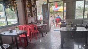 Un restaurante con sillas, mesas y un mostrador con diversos artículos.