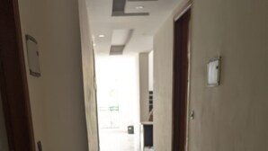 En hall med ett glänsande golv, en dörr till vänster och en dörr till höger.