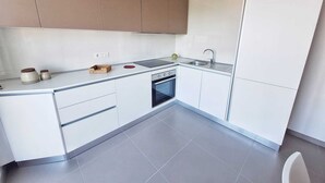 A modern kitchen with white cabinets, a built-in oven, and a stainless steel sink. - Air-conditioned apartment with sea view terrace - Santa Maria Castellabate (Castellabate)