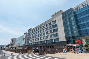 Un hotel de varios pisos con una fachada moderna, que cuenta con grandes ventanales y un letrero llamativo.