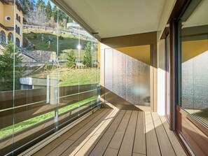 Ein Balkon mit Blick auf ein Gebäude und eine Rasenfläche.