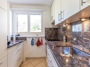 Eine Küche mit Fenster, Spüle und Schränken.