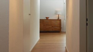 A hallway with wooden flooring, white walls, and a ceiling light fixture. - Friedberg 18 Appartement/Fewo, Dusche oder Bad, WC 3½-Zimmerwohnung by Interhome (Davos)