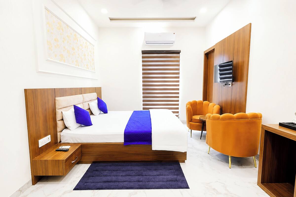 A modern bedroom with a bed, bedside table, and a desk area with a chair.