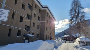 Un edificio de varios pisos con un cartel que indica restricciones de estacionamiento.