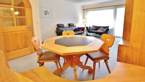 A dining area with a wooden table and chairs, a sofa, and a lamp. - Jasmin 202 Appartement/Fewo, Dusche oder Bad, WC 2½-Zimmerwohnung by Interhome (Davos)
