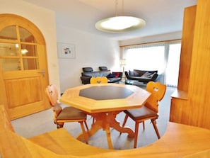 A dining area with a wooden table and chairs, a sofa, and a lamp. - Jasmin 202 Appartement/Fewo, Dusche oder Bad, WC 2½-Zimmerwohnung by Interhome (Davos)