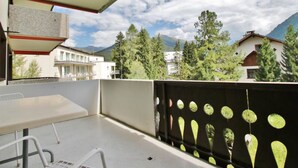 A balcony with a table and chairs, a view of buildings and trees, and a mountain in the background. - Jasmin 202 Appartement/Fewo, Dusche oder Bad, WC 2½-Zimmerwohnung by Interhome (Davos)