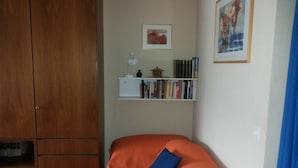 A bedroom with a bed, a bookshelf, a wardrobe, and a painting on the wall. - Golfpark B 14 Appartement/Fewo, Dusche oder Bad, WC 1½-Zimmerwohnung by Interhome (Davos)