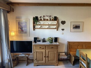 A cozy room with a TV, wooden cabinet, and a bed. - Albeina Hus Appartement/Fewo, Dusche oder Bad, WC 2-Zimmerwohnung by Interhome (Klosters)