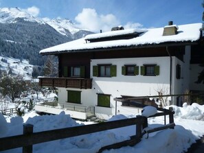 A two-story chalet with a balcony, surrounded by snow-covered mountains. - Albeina Hus Appartement/Fewo, Dusche oder Bad, WC 2-Zimmerwohnung by Interhome (Klosters)