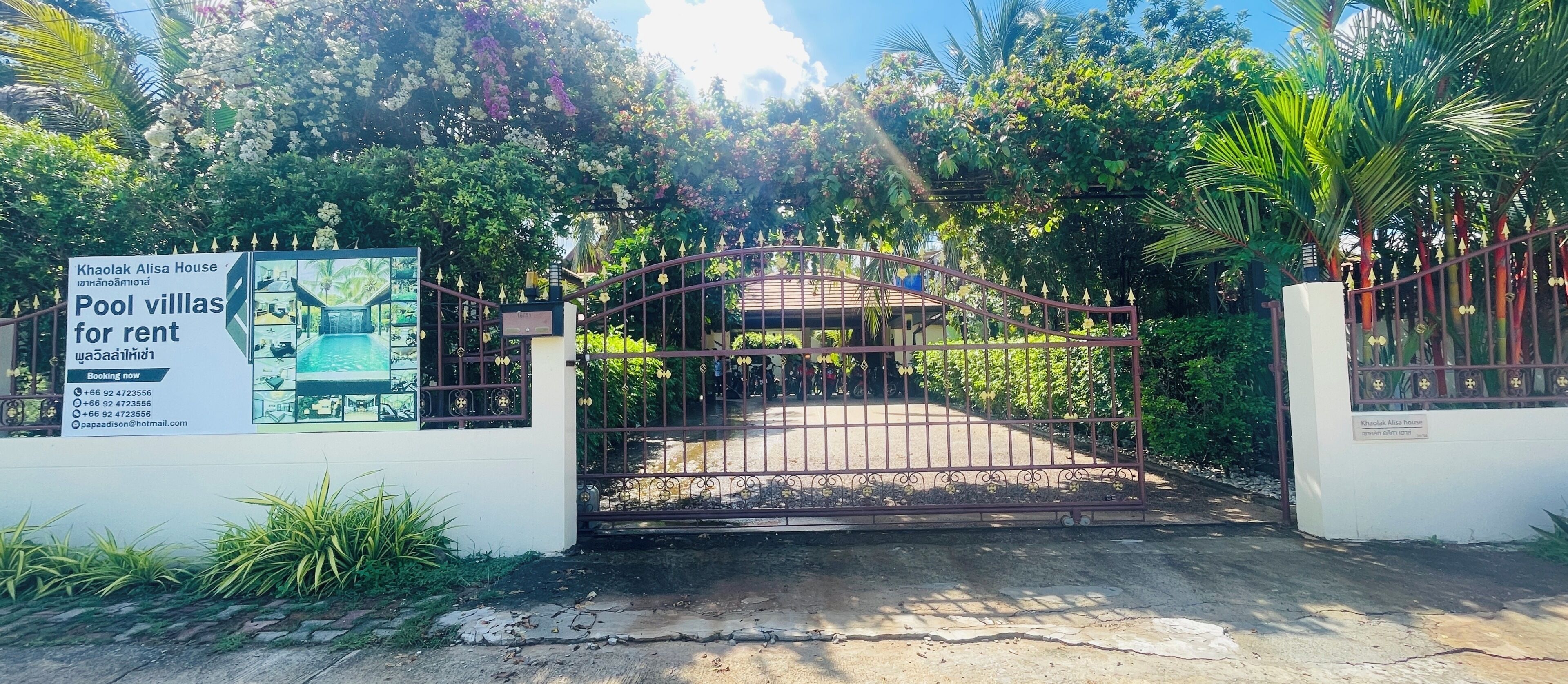 A gated entrance to a property with a sign advertising pool villas for rent.